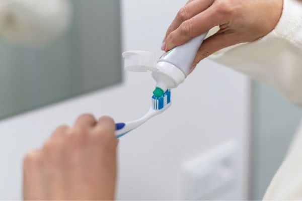Why are abrasive ingredients added to toothpaste?